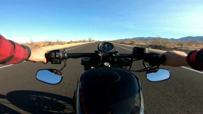 男子骑摩托车沿着沙漠直道行驶的视点