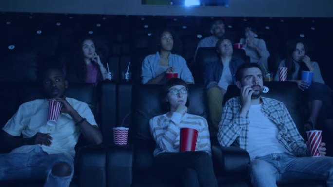 学生在电影院看电影的女孩和男孩注视着屏幕