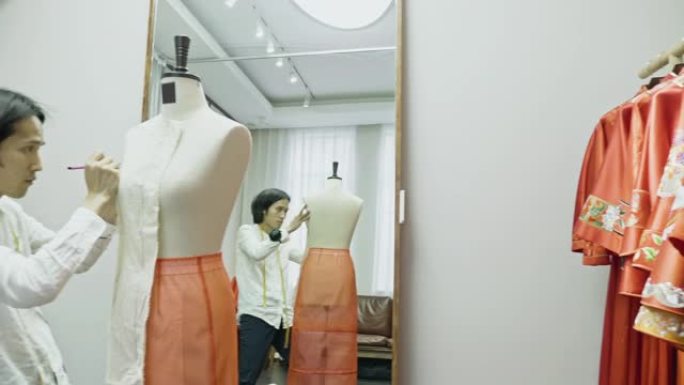 中年中国设计师在裁缝模型上标记图案