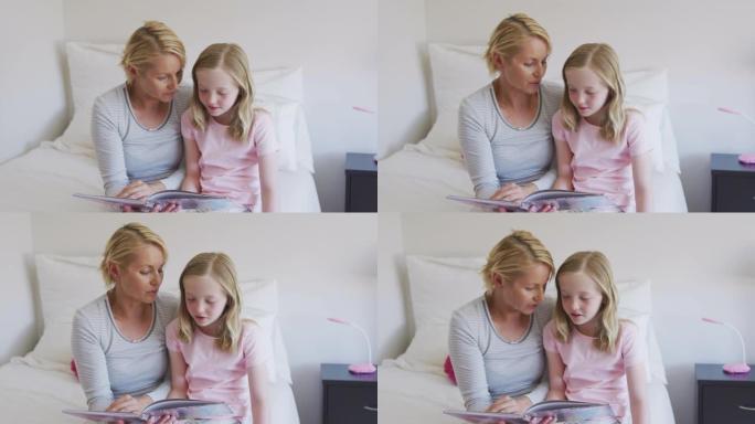 白人妇女在床上给女儿读故事的前视图
