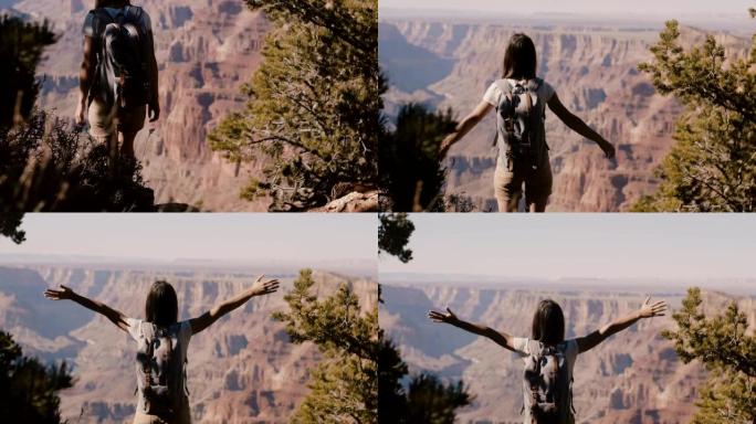 慢动作后视快乐的年轻旅游女子张开双臂站在那里观看史诗般的大峡谷山景。