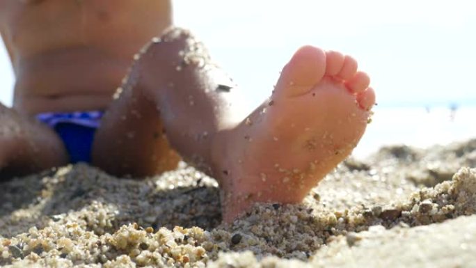 一个美丽的小女孩在海边的沙滩上玩耍的肖像，可爱的微笑，大海的背景是黄沙和蓝色的水。
