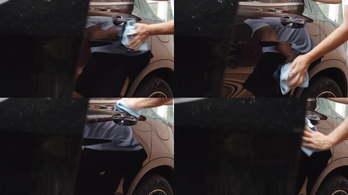 亚洲男子使用超细纤维擦拭清洁汽车。清除灰尘