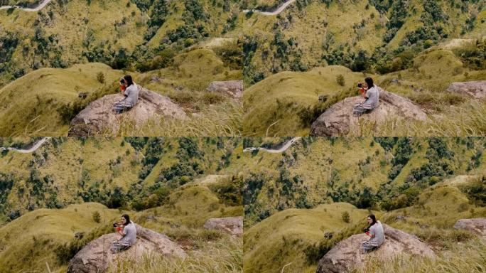 大气高角度拍摄，年轻的摄影师女子拍摄斯里兰卡美丽的山景全景照片。