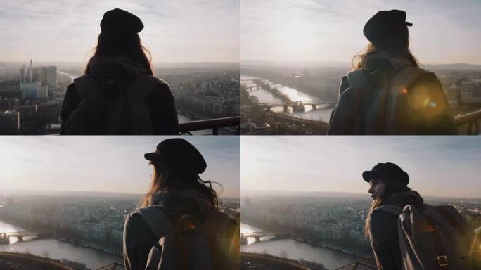 后视年轻快乐美丽的旅游女人，背着背包在埃菲尔铁塔上观看巴黎日落慢动作。