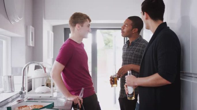 一群男大学生朋友在房子的共用厨房里闲逛，一边喝啤酒，一边吃披萨 -- 慢动作拍摄