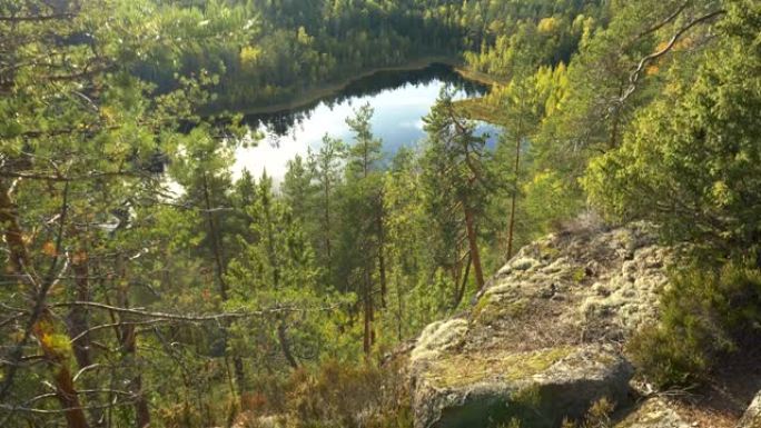 有树木、岩石和湖泊的景观。芬兰雷波韦西国家公园自然秋季景观的万向镜头