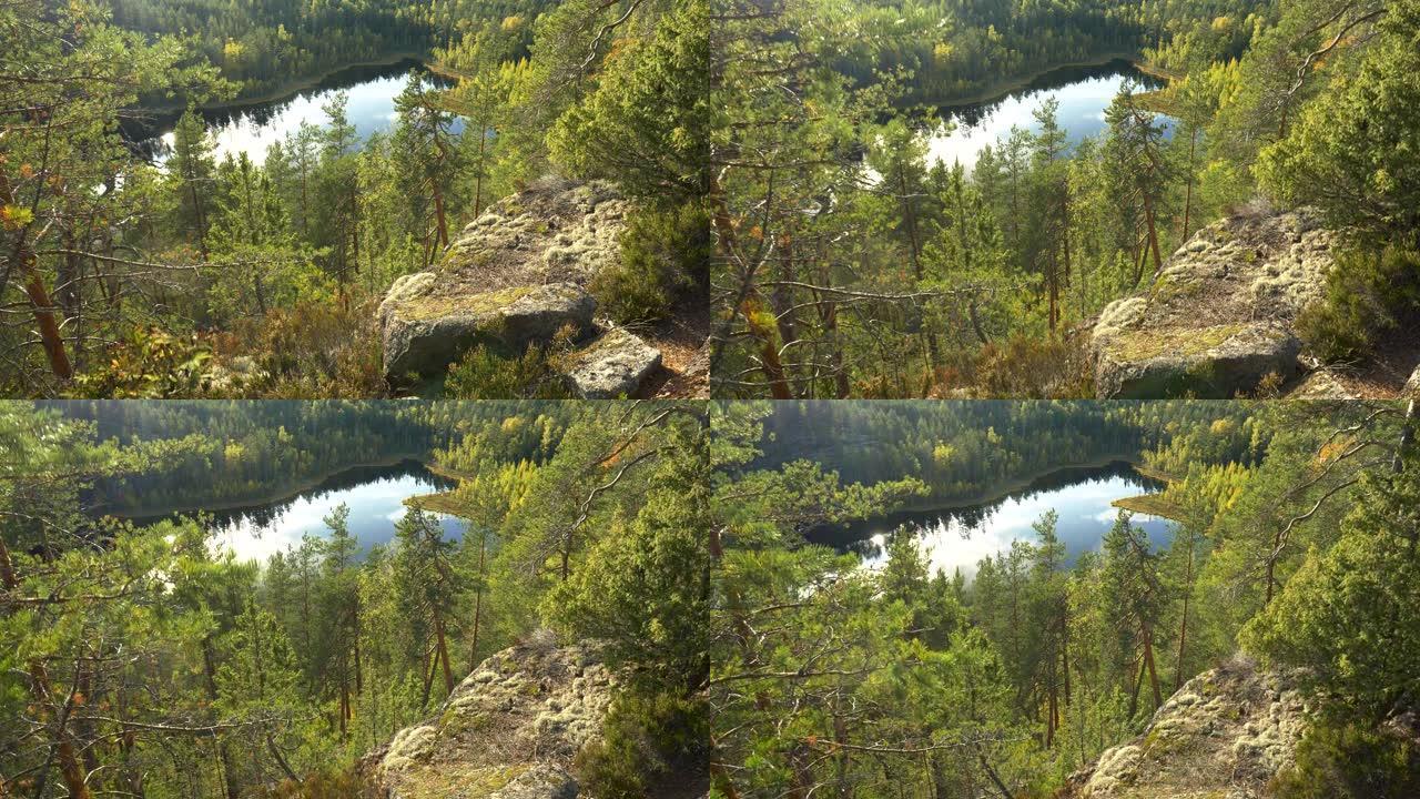 有树木、岩石和湖泊的景观。芬兰雷波韦西国家公园自然秋季景观的万向镜头