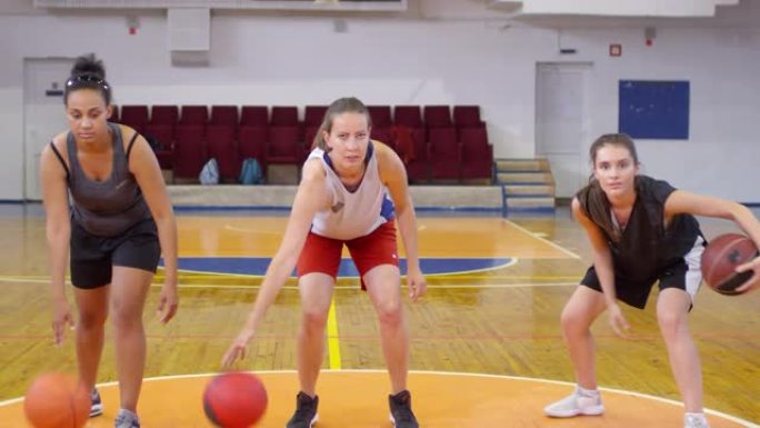 三名女运动员运球篮球并摆姿势拍照