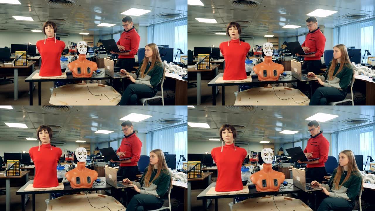 男人和女人用笔记本电脑控制机器人，特写镜头。
