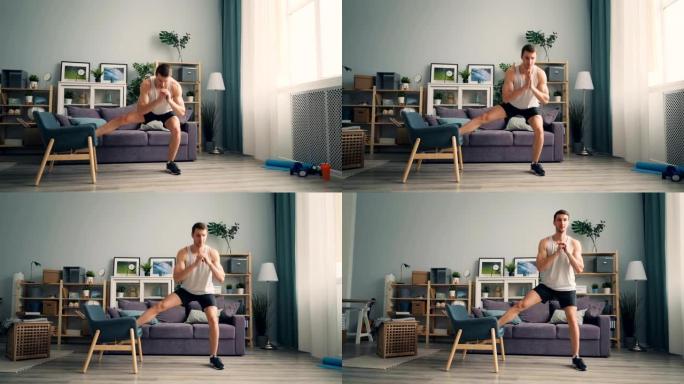 帅哥运动员在公寓里用扶手椅蹲坐，享受运动