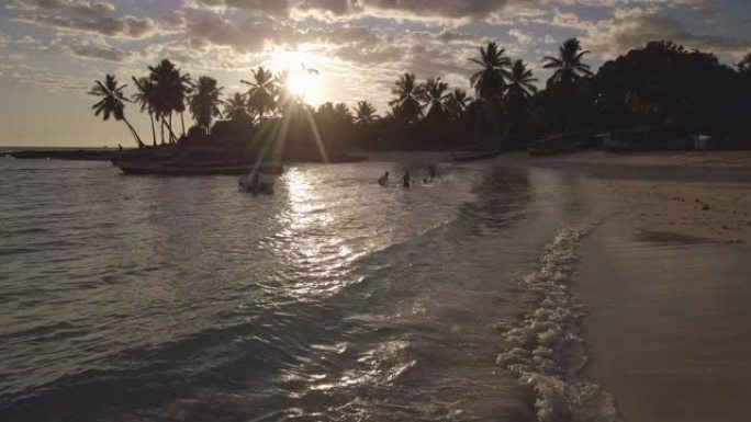 鸟瞰壮丽的日落景观: 一个拥有白色海滩、清澈见底的大海、棕榈树的岛屿。梦幻度假的好地方。