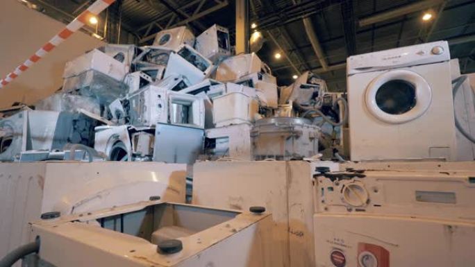 回收工业概念，塑料垃圾回收工厂。垃圾场单元中的一堆破碎的家用电器