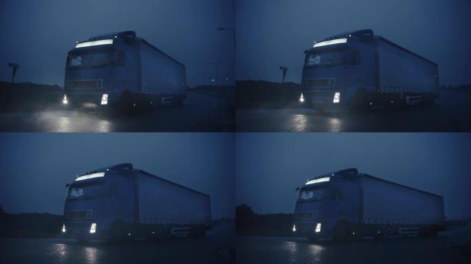 满载货物拖车的长途半卡车在高速公路上行驶。清晨开车穿越大陆，穿过雨，雾。工业仓库区。慢动作拍摄后的正