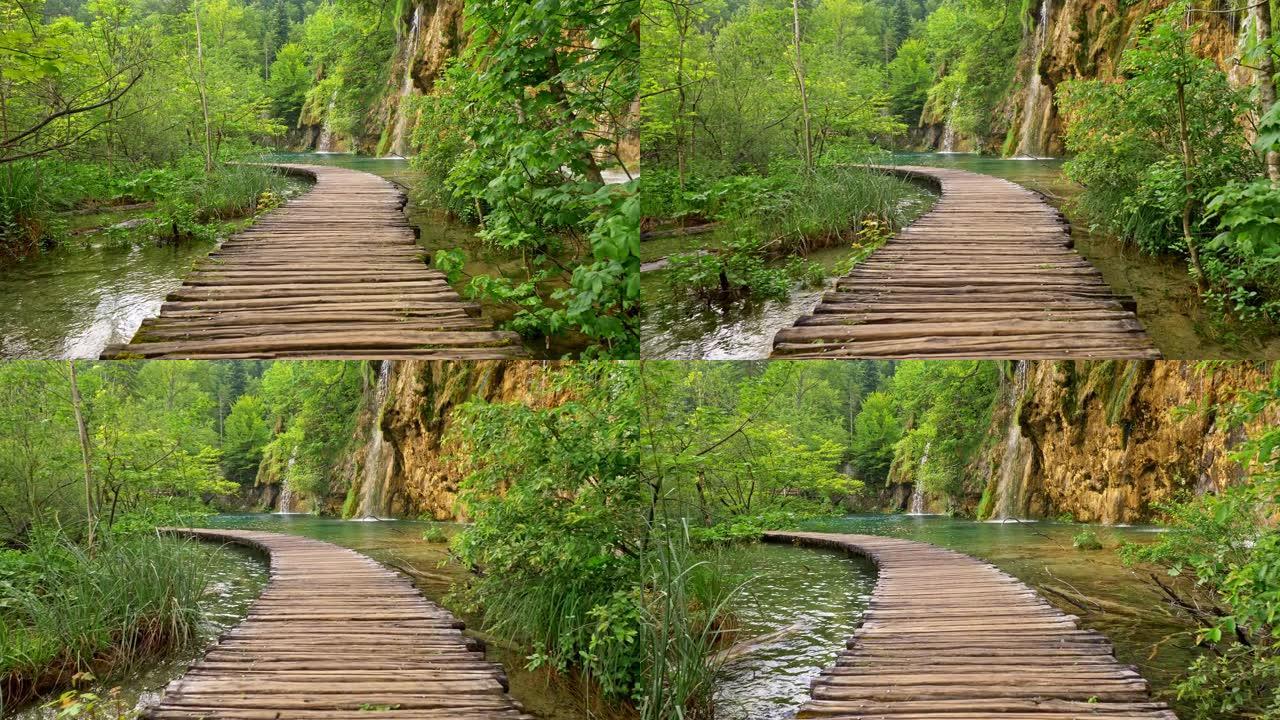 在克罗地亚十六湖国家公园的湖泊和瀑布之间的木制木板路以及丰富的绿色植物区系中漫步。Steadicam