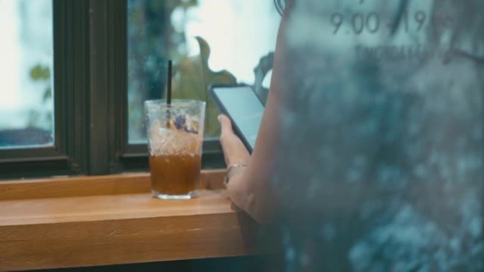在咖啡店使用智能手机的女人