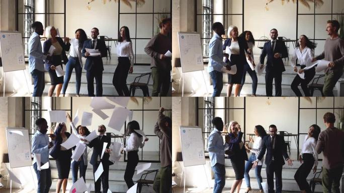 无忧无虑的多种族商人在办公室跳舞扔纸