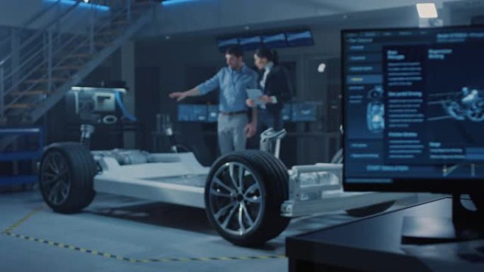 汽车工业设计设施屏幕显示3D cad软件: 男总工程师向女发明家展示汽车原型。电动汽车平台底盘概念有