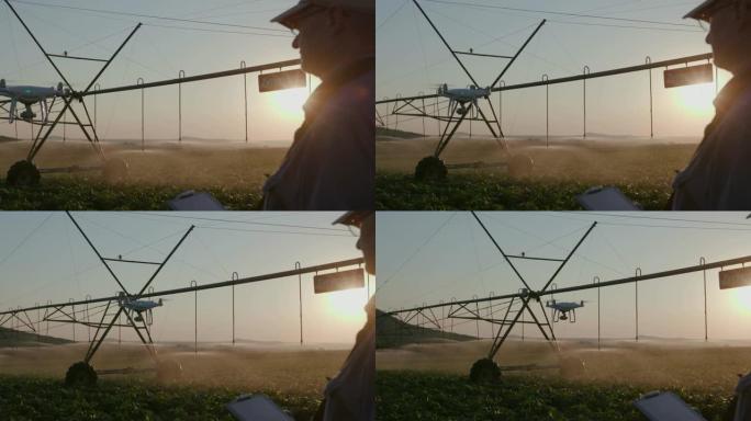 4k背光视图，一个现代农民用无人机在一个大型蔬菜农场使用先进技术监控他的蔬菜作物，背景是中心枢轴