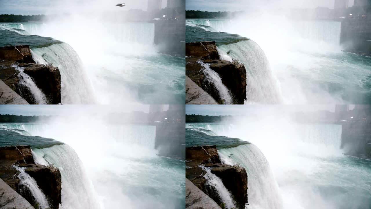 在史诗般的尼亚加拉大瀑布慢动作中，汹涌的水流冲下岩石，鸟儿飞舞的惊人特写镜头。
