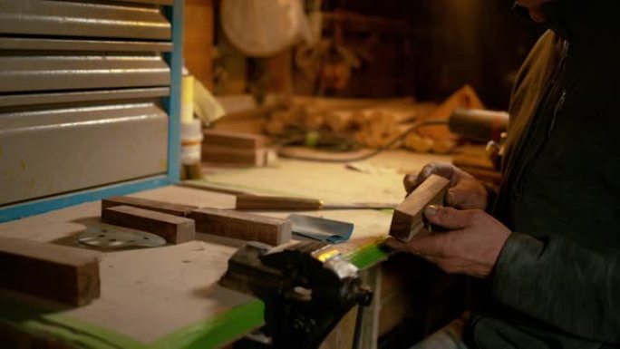 特写: 工匠在制作刀柄之前检查一块木头。