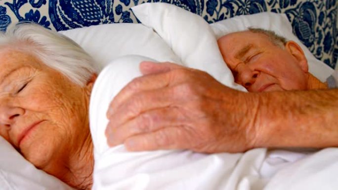 白人老年夫妇睡在舒适家庭4k卧室的床上的特写