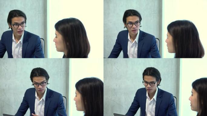 亚洲中国男女同事在公司办公室里聊天