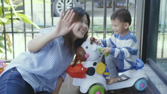 4k慢动作镜头亚洲小男孩和姐姐一起玩玩具车充满幸福在现代房子的前草坪上进行自我学习或家庭学校，家庭和