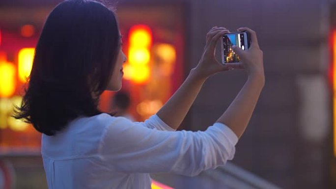 女人在城市用手机拍照