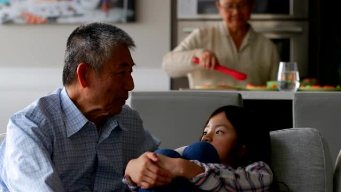 可爱的亚洲孙女在家里与她的老祖父互动的前视图4k