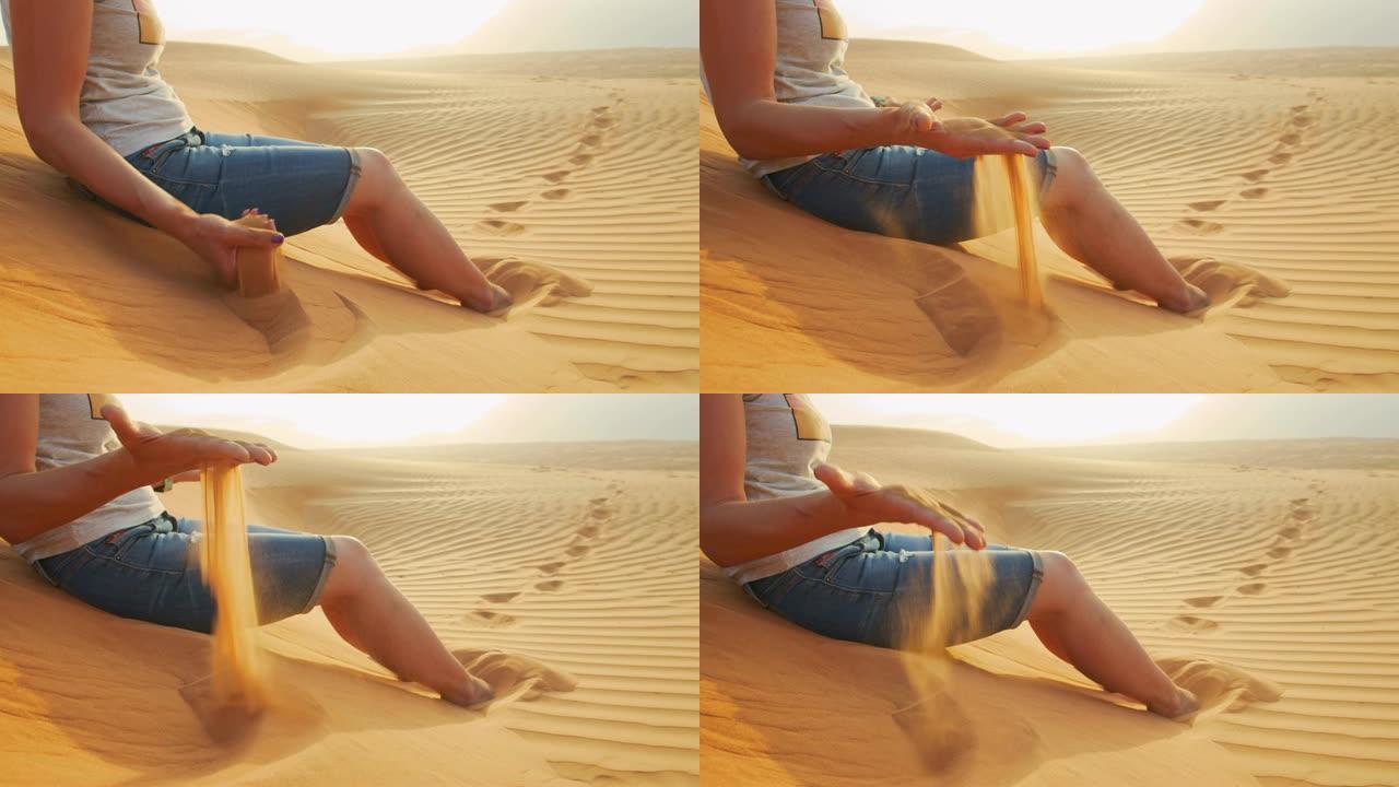 女士坐在沙丘上，慢动作