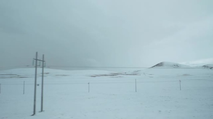 乘坐火车沿着穿越西藏雪原的电力线