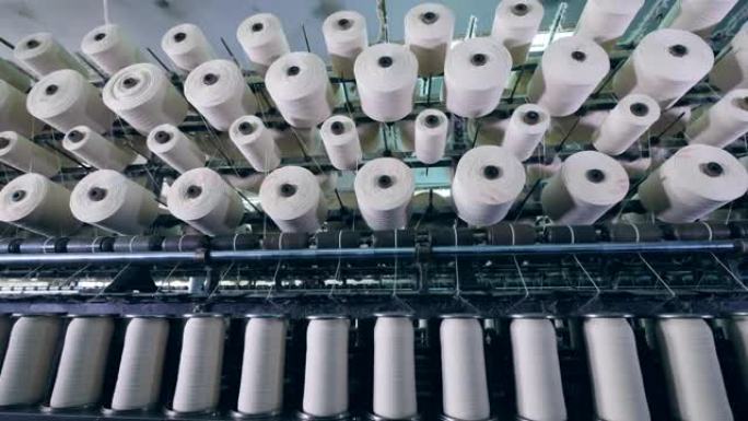 一排排带有纤维的线轴，在纺织厂缠绕。工业用纺织品生产线