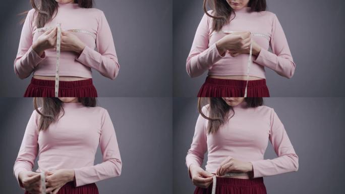 迷人的亚洲女性或时髦女性测量她的乳房。工作的女孩用卷尺检查她的胸部大小。拥有医疗保健或时尚概念的美容