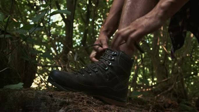 男人在森林里系鞋带