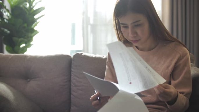 亚洲妇女在家中阅读文件