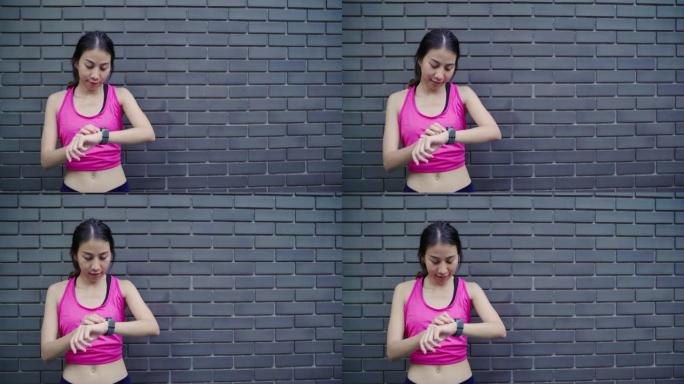 健康美丽的年轻亚洲运动员女子在城市跑步时，在智能手表上设置和检查进度查看心率监视器。生活方式女性在城