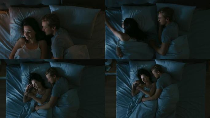 晚上躺在床上的顶视图夫妇: 男友亲吻女友晚安，她关掉灯，他们在彼此的怀里睡着了。