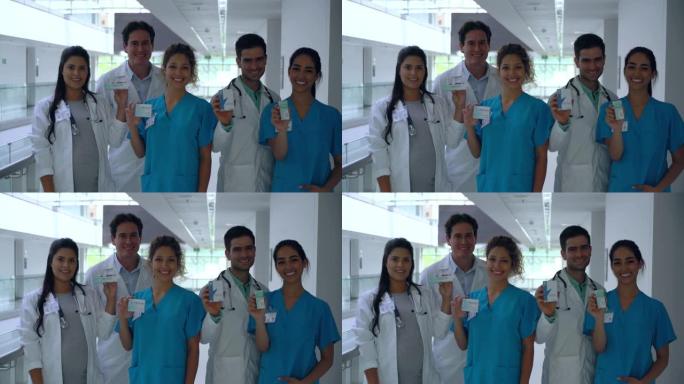 医院的拉丁美洲专业医护人员团队面对镜头微笑着拿着处方药