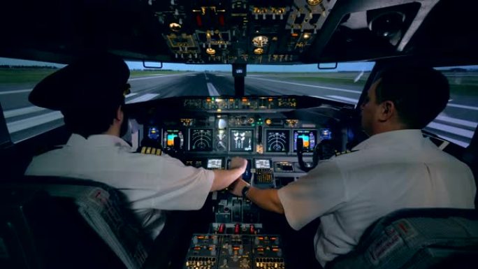 男飞行员正在帮助他的受训者控制飞机模拟器。现代客机机舱内部。