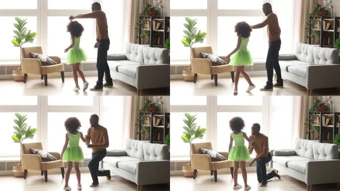 快乐的非洲爸爸和小女儿在客厅跳舞