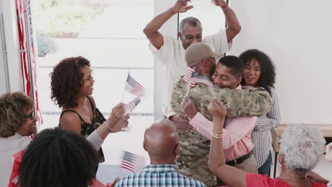 年轻的黑人士兵返回一个惊喜的家庭欢迎回家派对，高视阔步