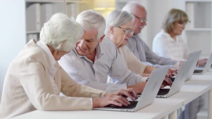 在计算机课上使用笔记本电脑的老年人