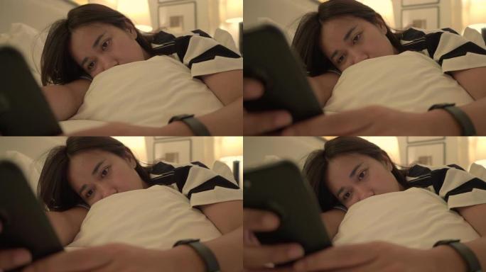女人用手机晚上躺在床上