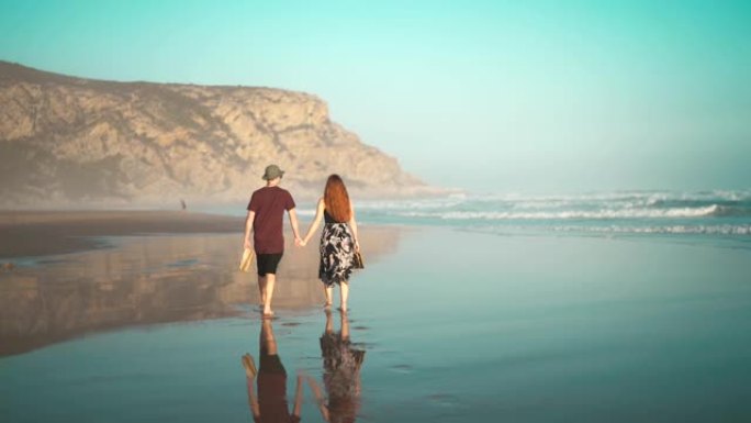 热恋中的情侣在海滩上散步