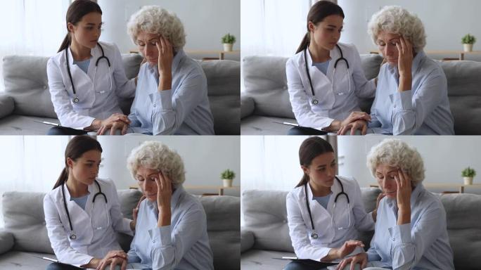 年轻女护士医生支持安慰沮丧的老奶奶病人