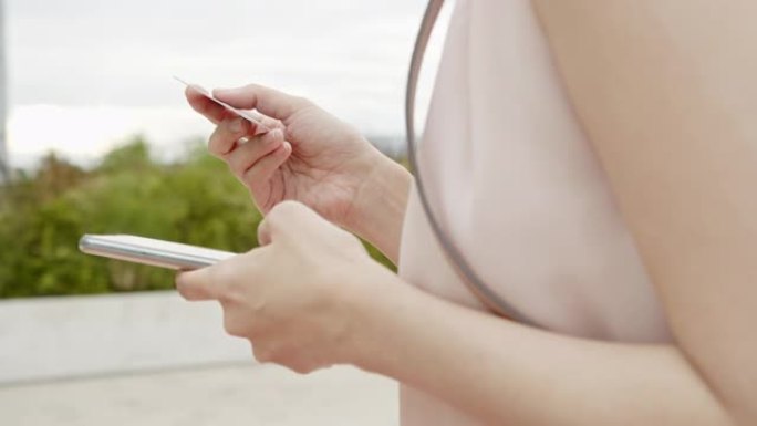 亚洲女性使用智能手机并支付账单。