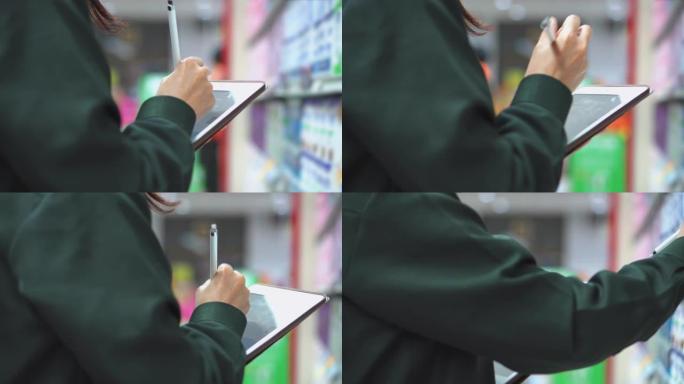 在超市中使用数字平板电脑检查产品的女售货员