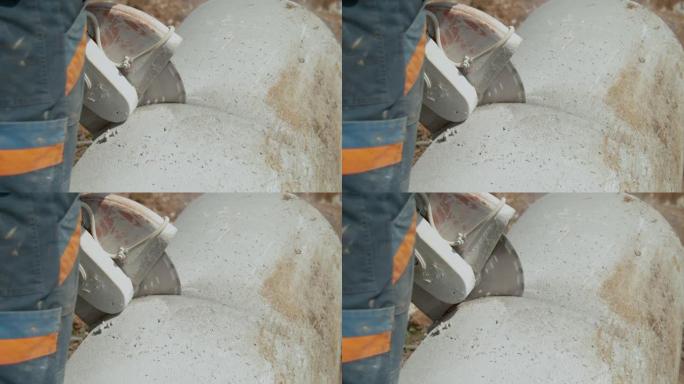 关闭无法识别的工人用圆锯切割一个大混凝土管