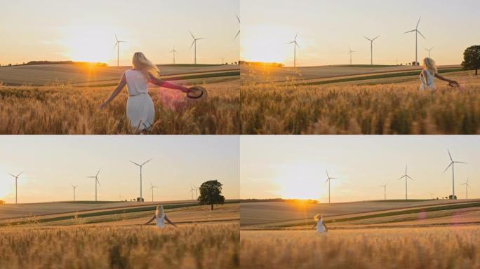 妇女戴着太阳帽跑过麦田，远处有风力涡轮机